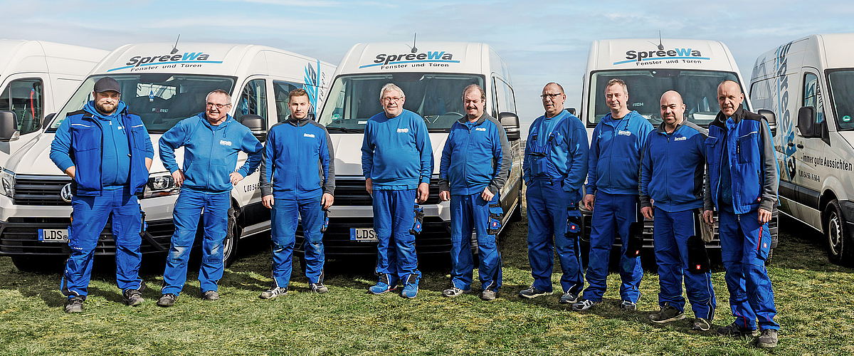 Eine Gruppe von Spree-Wa Mitarbeitern stehen vor Firmen-Transportern